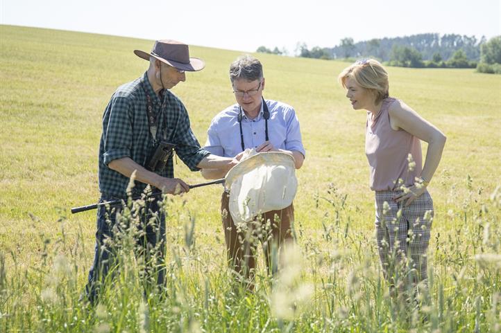 Frank Gottwald (links) zeigt Frau Klöckner die Insektenfunde auf ungemähten Streifen im Luzerne-Kleegras. | Quelle: © Julia Thiemann / WWF Deutschland.