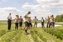 Gruppe von Menschen arbeitet auf einem Feld des Berliner Unternehmens Tiny Farms.