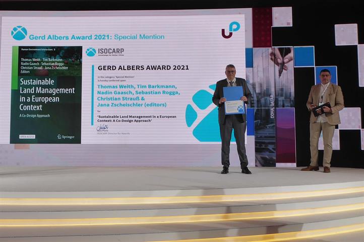 Eine Publikation zum Thema Landmanagement des Leibniz-Zentrums für Agrarlandschaftsforschung (ZALF) e.V. wurde von der von der International Society of City and Regional Planners (ISOCARP) ausgezeichnet. Prof. Thomas Weith nahm den Preis am 10. November 2021 entgegen. | Quelle: © Thomas Weith / ZALF.