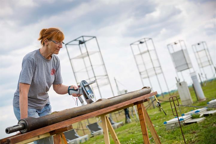 Wissenschaftlerin untersucht eine Bodenprobe im Feld.